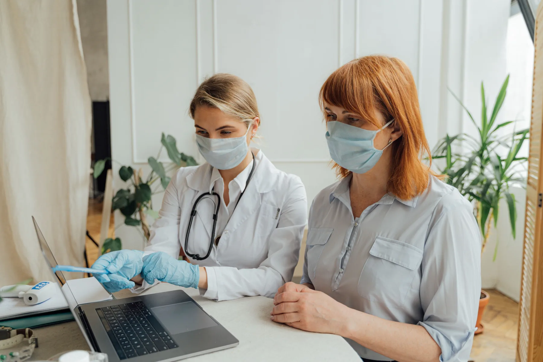 A clinician reviewing results with a patient at a laptop